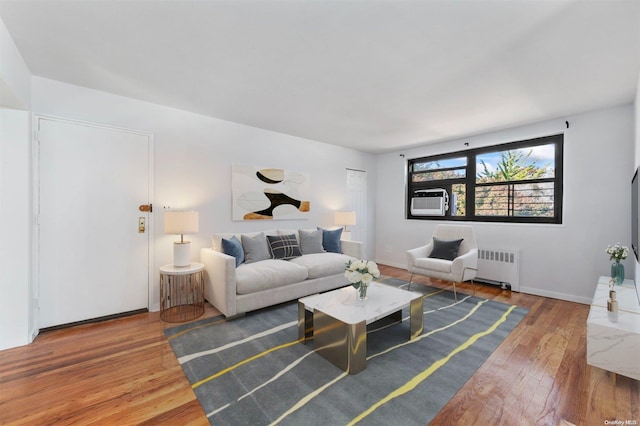 living room featuring hardwood / wood-style flooring, cooling unit, and radiator heating unit