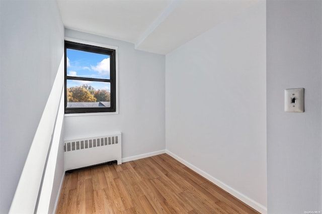 additional living space featuring light hardwood / wood-style flooring and radiator