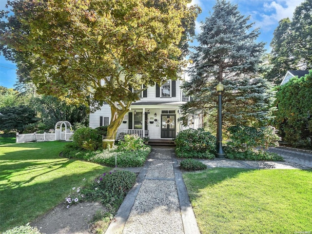 view of front of home featuring covered porch and a front lawn