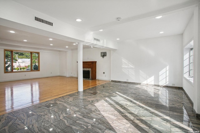 unfurnished living room with dark hardwood / wood-style flooring and ornamental molding