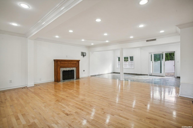 unfurnished living room featuring crown molding and light wood-type flooring