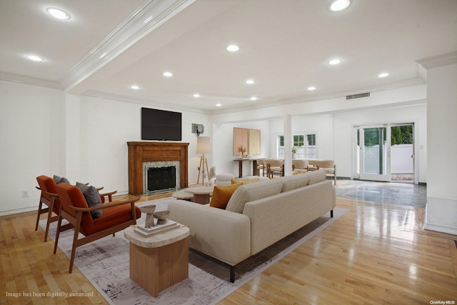 living room featuring light wood-type flooring and crown molding