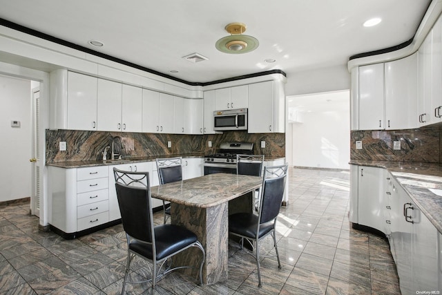 kitchen with tasteful backsplash, white cabinetry, and stainless steel appliances