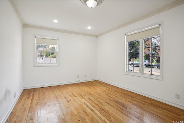 spare room with crown molding and light hardwood / wood-style floors