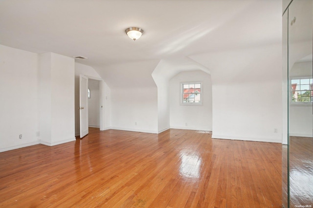 interior space featuring light wood-type flooring and vaulted ceiling