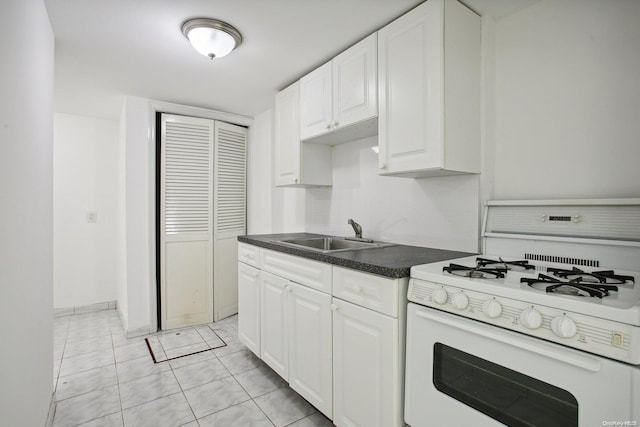 kitchen featuring sink, white cabinetry, white gas range oven, and light tile patterned floors