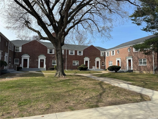 townhome / multi-family property featuring a front lawn