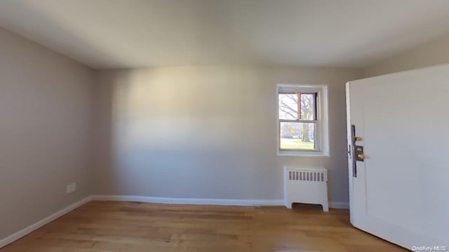 empty room with radiator and light wood-type flooring