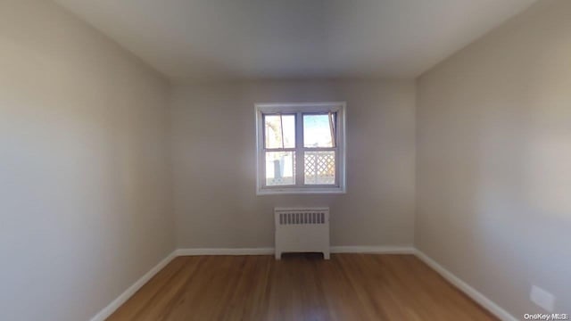 empty room featuring hardwood / wood-style floors and radiator