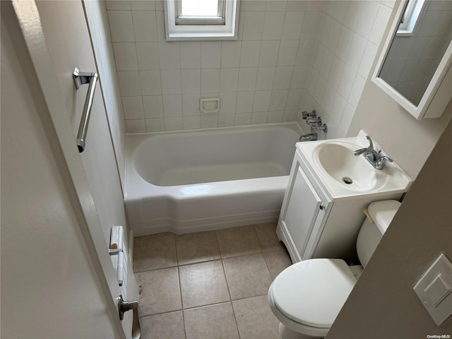 full bathroom featuring tile patterned floors, vanity, tiled shower / bath combo, and toilet