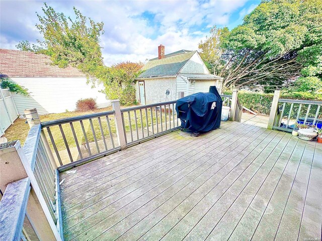 wooden deck featuring a grill