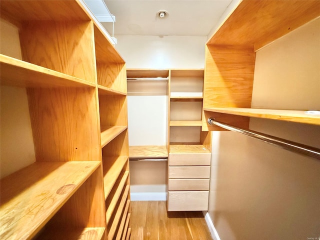 walk in closet with light wood-style flooring