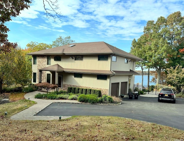 back of house with a water view and a garage