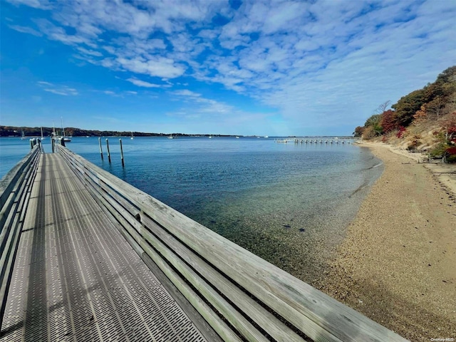 view of dock featuring a water view and a view of the beach