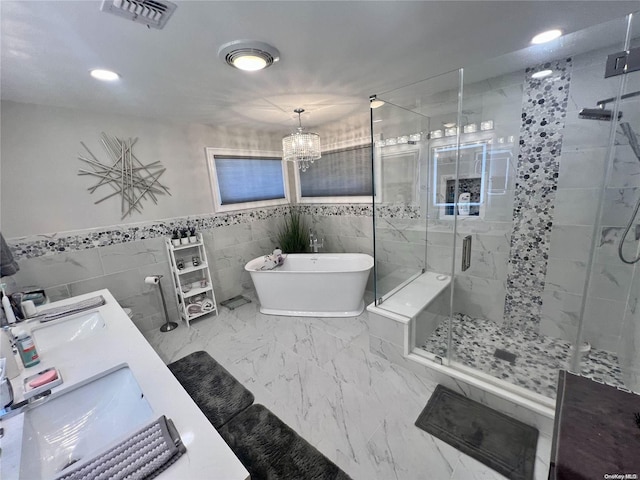 full bathroom with visible vents, marble finish floor, a freestanding bath, a shower stall, and a sink