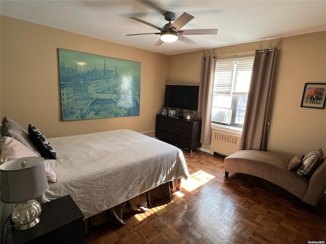 bedroom with ceiling fan, radiator heating unit, and parquet flooring