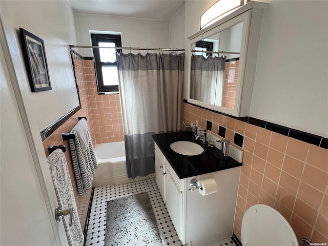 full bathroom featuring vanity, tile patterned flooring, toilet, shower / bathtub combination with curtain, and tile walls