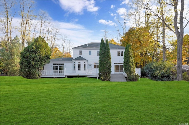 back of property with a lawn and a wooden deck