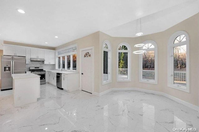 kitchen with pendant lighting, plenty of natural light, white cabinetry, and appliances with stainless steel finishes