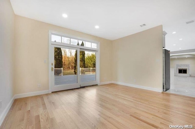 empty room featuring a fireplace and light hardwood / wood-style floors