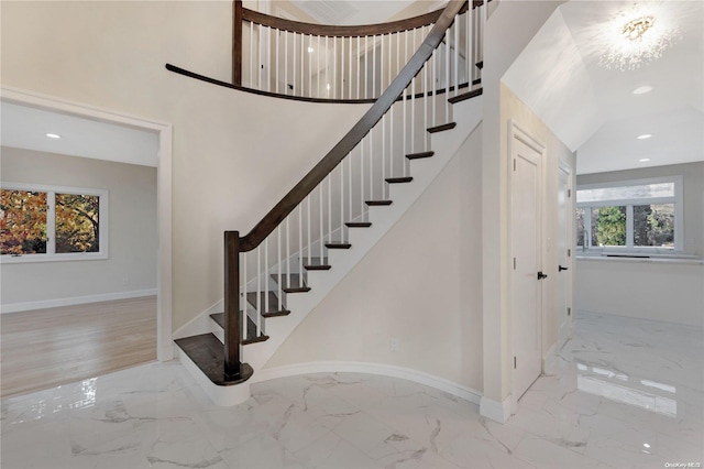 stairway featuring wood-type flooring and an inviting chandelier