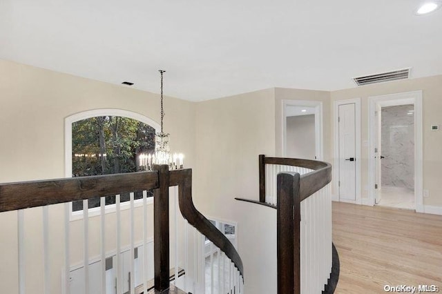 hall with a chandelier and light hardwood / wood-style flooring