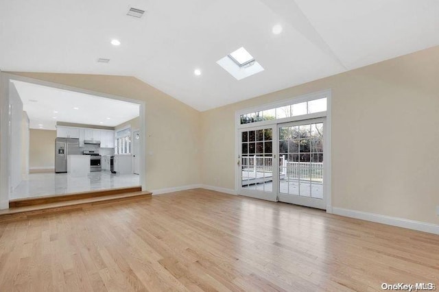 unfurnished living room featuring light hardwood / wood-style floors and lofted ceiling with skylight