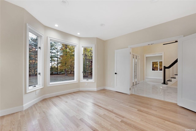 unfurnished room with light wood-type flooring and plenty of natural light