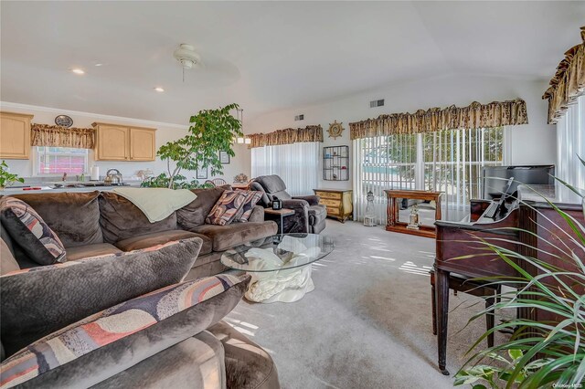 living room with light colored carpet, vaulted ceiling, ceiling fan, and ornamental molding