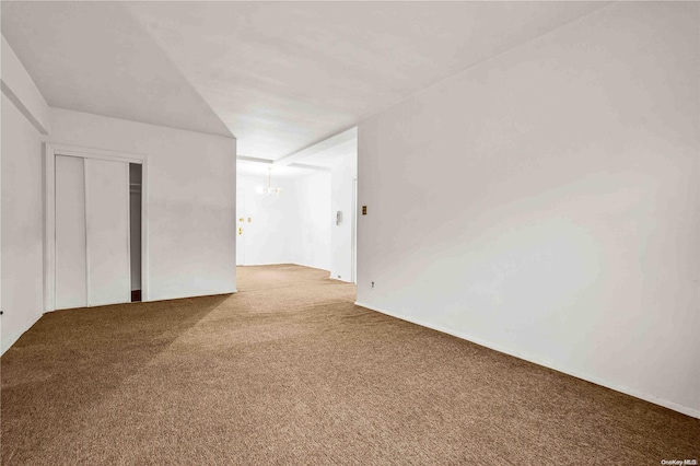 unfurnished room featuring carpet and a chandelier