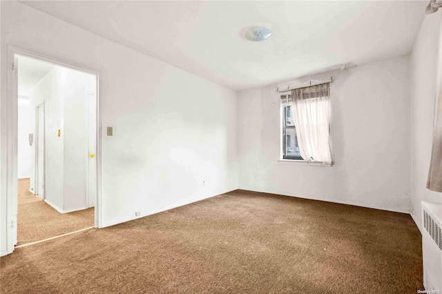 unfurnished room with carpet flooring and radiator heating unit