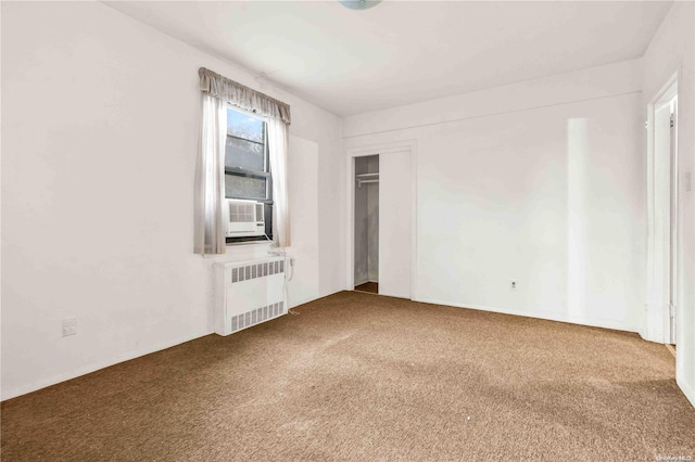 carpeted spare room with radiator and cooling unit