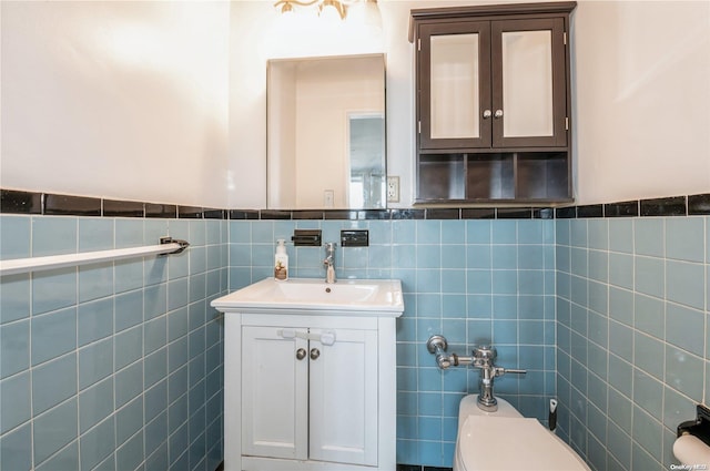 bathroom featuring tile walls, vanity, and toilet