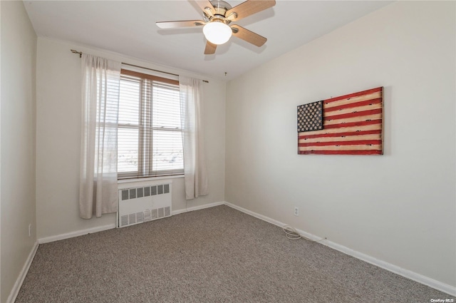 spare room featuring carpet flooring, ceiling fan, and radiator heating unit