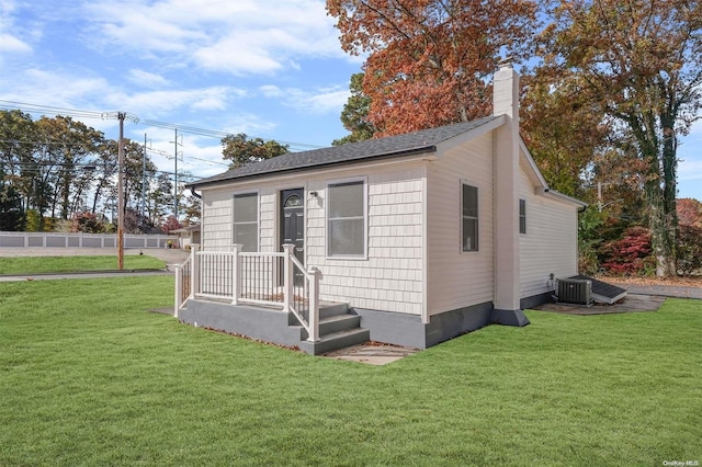 exterior space with central AC unit and a front lawn