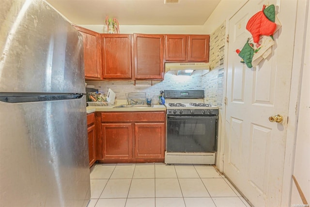 kitchen featuring sink, stainless steel fridge, light tile patterned floors, tasteful backsplash, and range