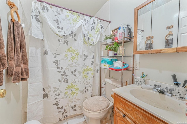 bathroom featuring tile patterned flooring, vanity, toilet, and walk in shower