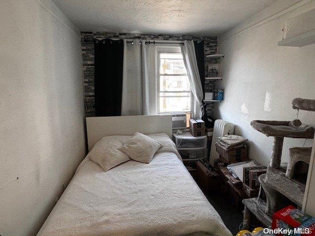 bedroom featuring cooling unit and a textured ceiling