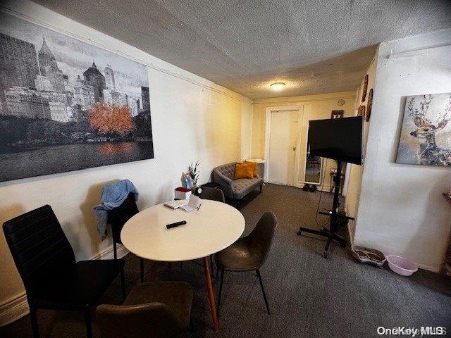 carpeted dining room featuring a textured ceiling