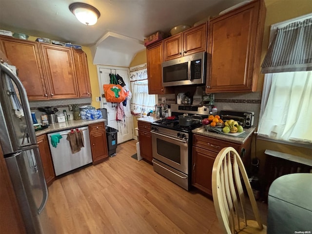 kitchen featuring light hardwood / wood-style floors, stainless steel appliances, and tasteful backsplash