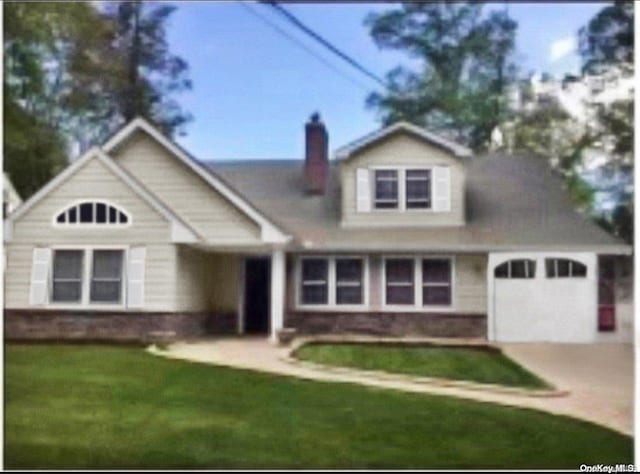 view of front of house featuring a garage and a front lawn