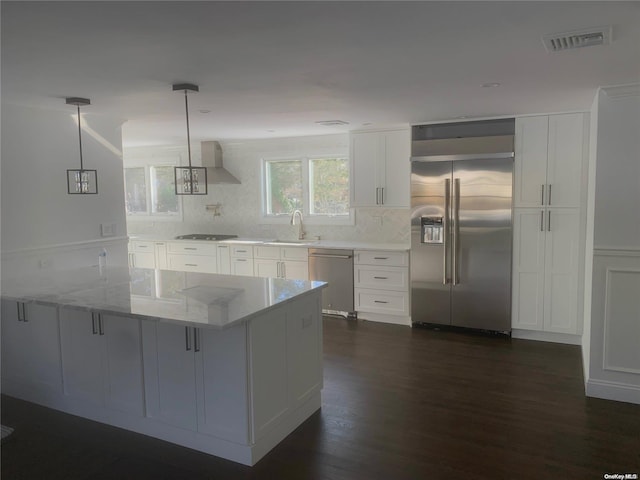 kitchen with decorative light fixtures, light stone countertops, white cabinetry, and stainless steel appliances