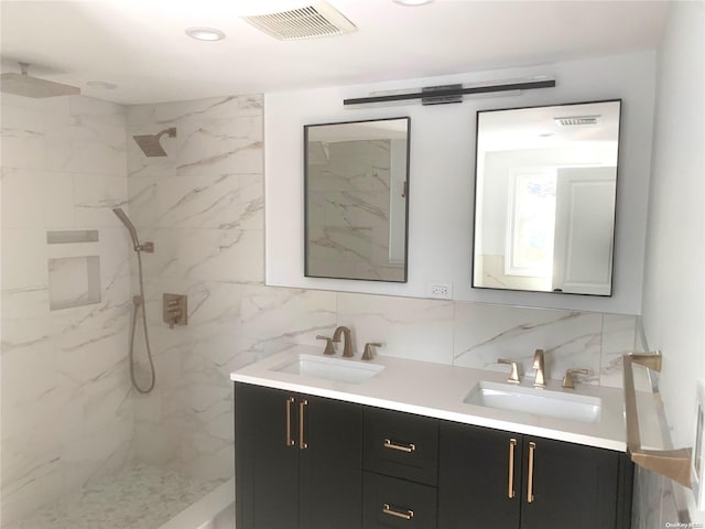 bathroom featuring a tile shower, tasteful backsplash, and vanity