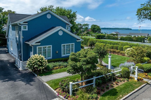 view of property exterior with a yard and a water view