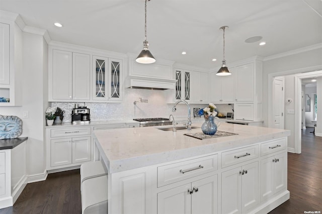 kitchen featuring white cabinets, dark hardwood / wood-style floors, a kitchen island with sink, and sink