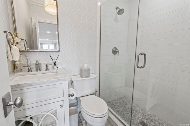 bathroom featuring vanity, toilet, and a shower with shower door