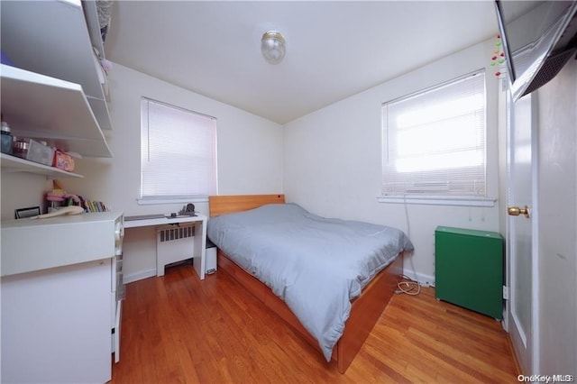 bedroom featuring light hardwood / wood-style flooring and radiator