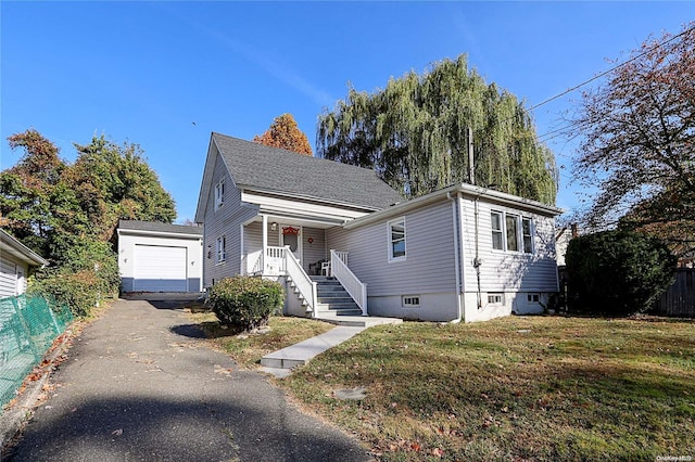 view of front of home featuring a garage, an outbuilding, and a front lawn