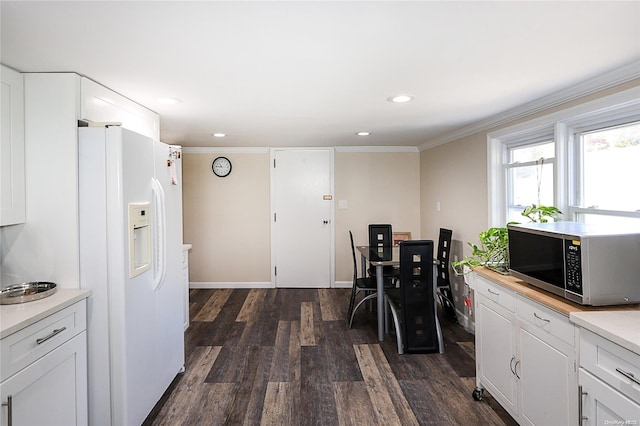 kitchen with white refrigerator with ice dispenser, ornamental molding, white cabinets, and dark wood-type flooring