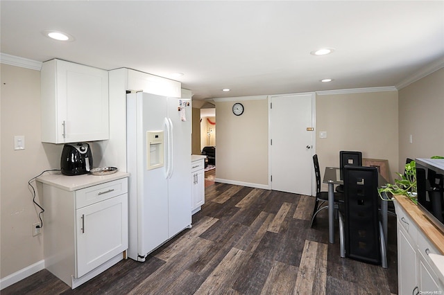 kitchen with white cabinetry, dark hardwood / wood-style flooring, crown molding, and white refrigerator with ice dispenser